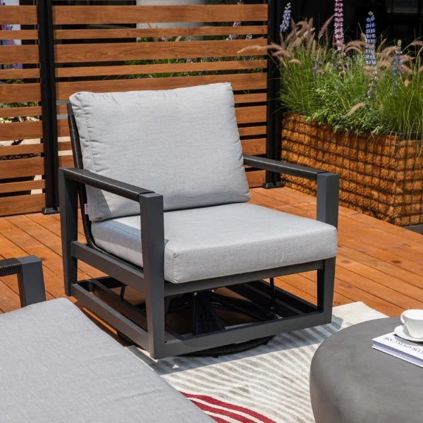 Outdoor lounge chair with gray cushions on a wooden deck with plants in the background