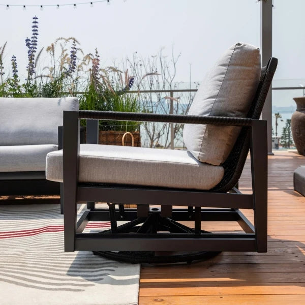 Outdoor swivel glider chair with cushions on a wooden deck with plants and a view in the background