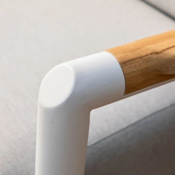 Close-up of a modern L-shaped armrest corner with a matte white finish and a natural light wood handle on a light gray upholstered chair.