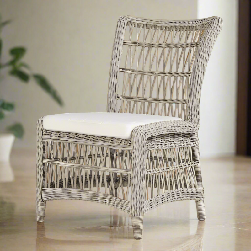 A white Lloyd Flanders Mackinac woven vinyl armless dining chair with a cushioned seat and backrest, placed in a room setting.