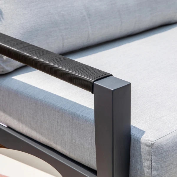 Close-up of a gray outdoor swivel glider with a black aluminum frame armrest.