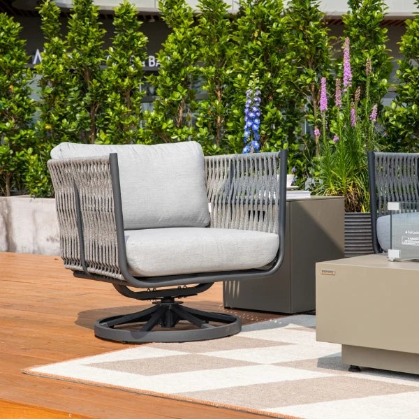 Outdoor patio chair with gray cushion on a wooden deck surrounded by greenery