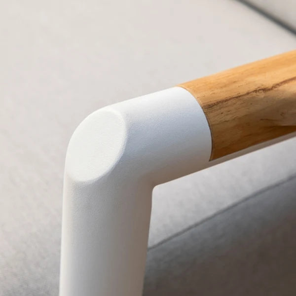 Close-up of a modern L-shaped armrest corner with a matte white finish and a natural light wood handle on a light gray upholstered chair.