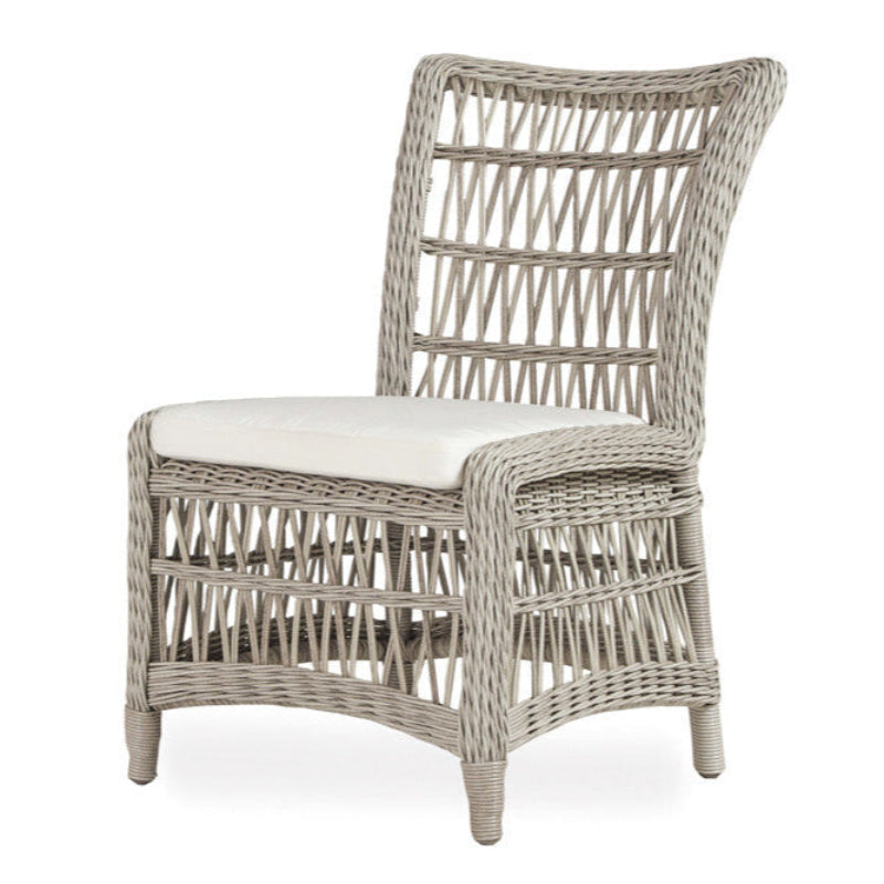 An armless dining chair with a woven vinyl seat and a cushioned backrest and seat, inspired by Mackinac Island styling.